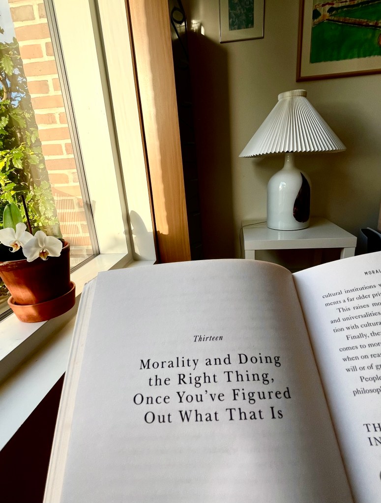 Stranica sa citatom iz knjige Behave, prozor, lampa i orhideja u pozadini