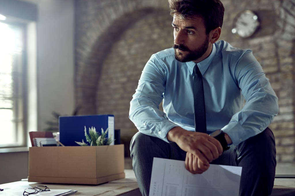 Poslovni čovek sedi na stolu i razmišlja, dilema inovatora